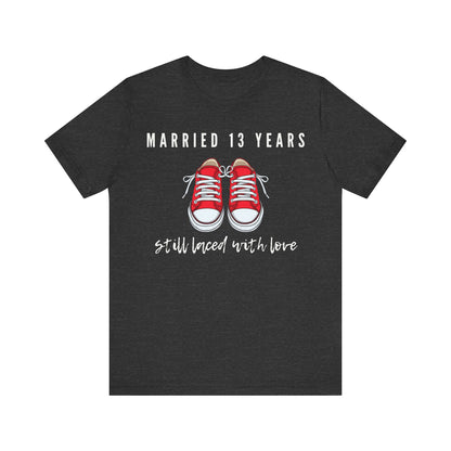 Dark grey anniversary T-shirt with the text Married 13 Years Still Laced With Love around two cartoon sneakers