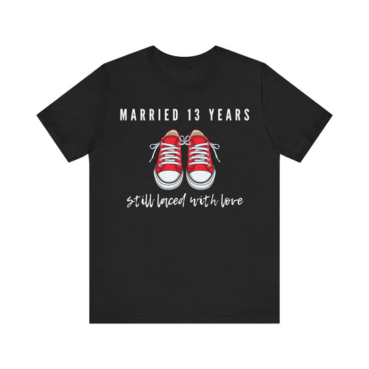 Black anniversary T-shirt with the text Married 13 Years Still Laced With Love around two cartoon sneakers